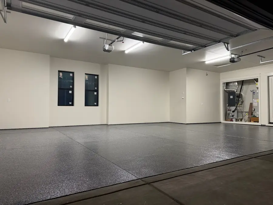 Large garage with a light flake floor and windows